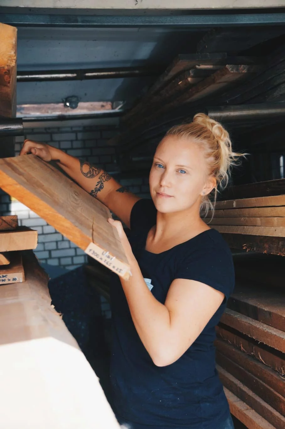Nora Nallinger in ihrer Werkstatt, mit einem Holzbrett in der Hand